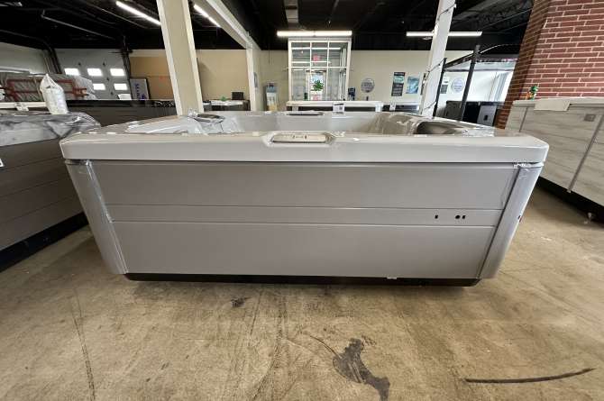 A bullfrog A5L spa being showcased indoors from a front facing angle in a costal grey color.