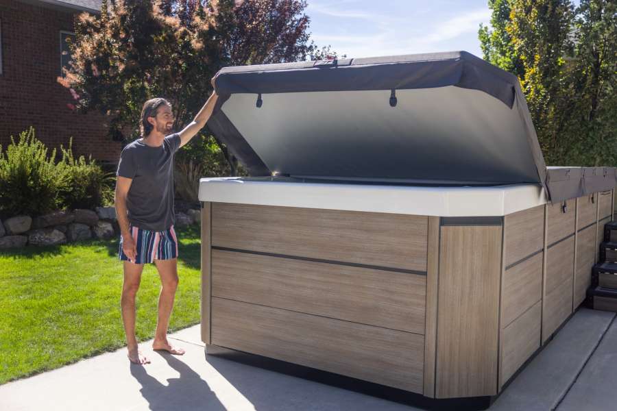 A man closing his bullfrog spas cover.