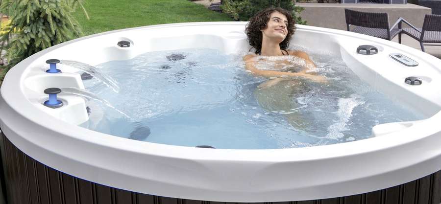 A celebrity series hot tub being showcased outside with people enjoying a relaxing time.