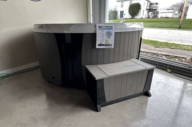 An Elite Series spa being displayed indoors with some natural lighting.